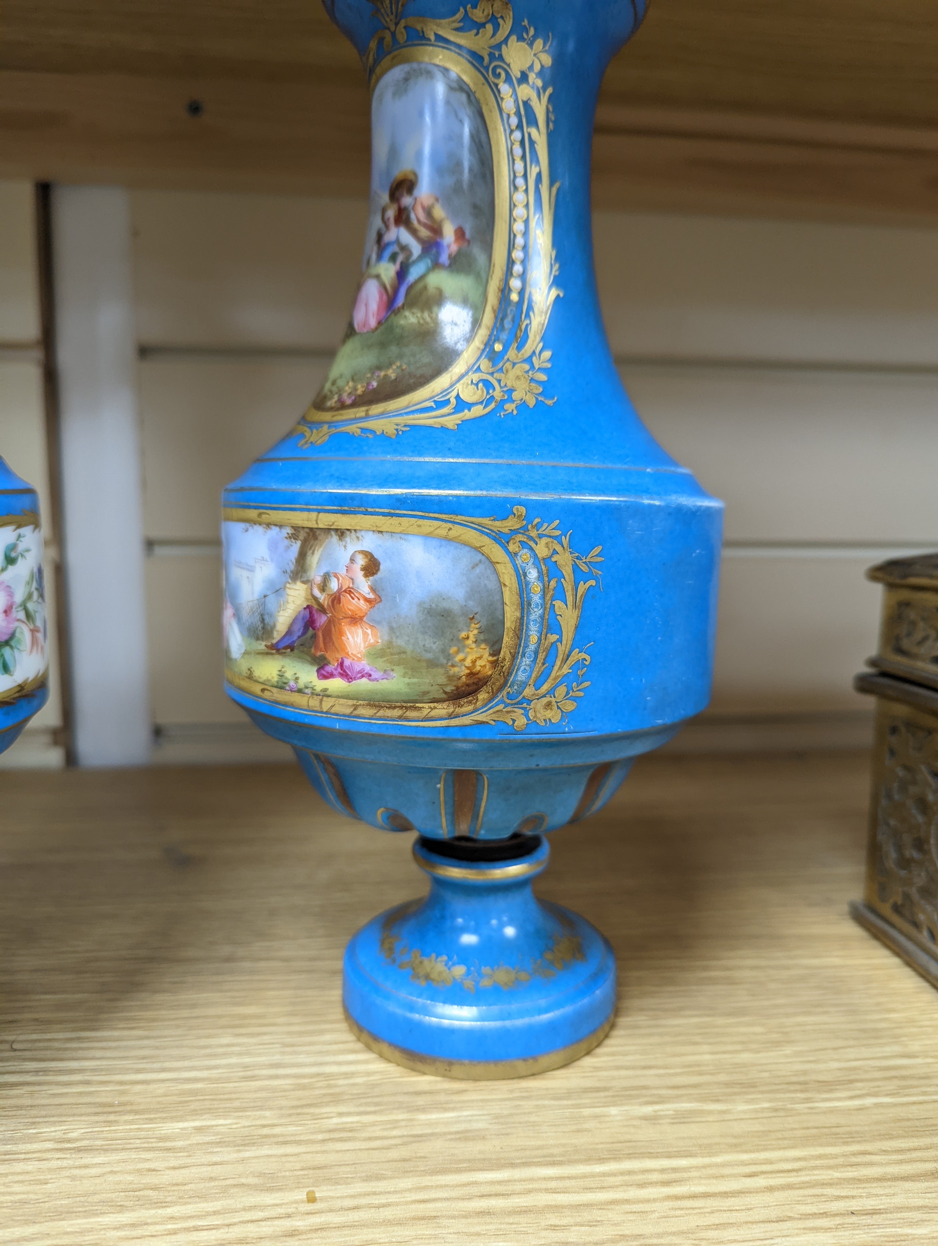 A pair of Sevres style porcelain bleu celeste ground vases and covers, 34cm